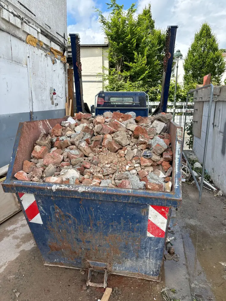 Ein beladener Container mit Bauschutt mit Anhaftungen