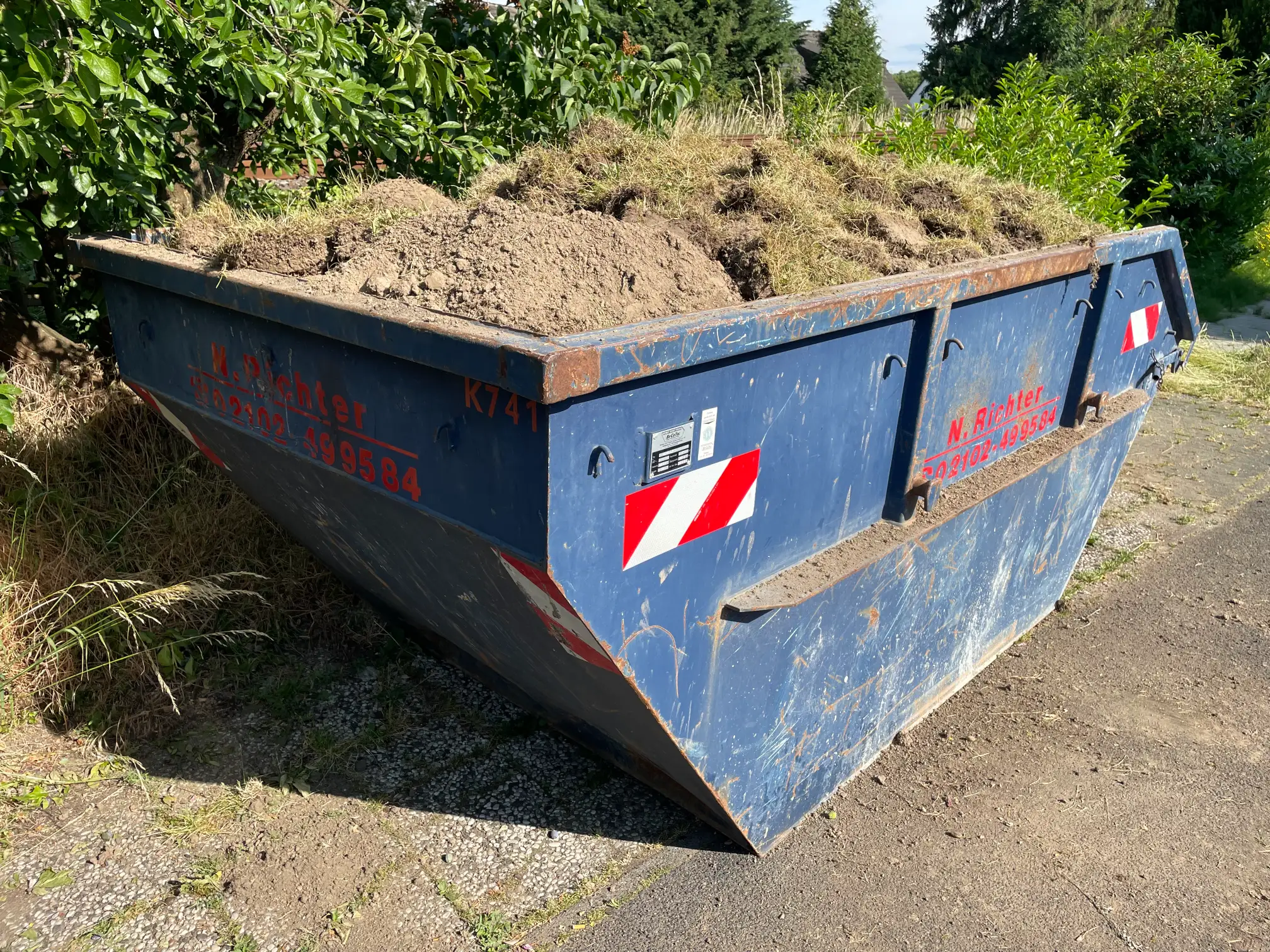 Ein Container voll mit Boden mit Grasnarben und Wurzeln