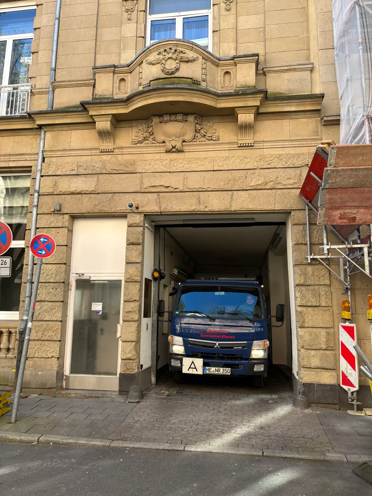Der LKW fährt durch eine enge zufahrt in eine Tiefgarage